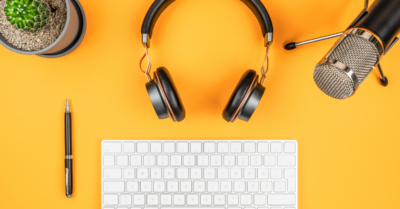 keyboard, headphones, microphone and pen on a yellow table 