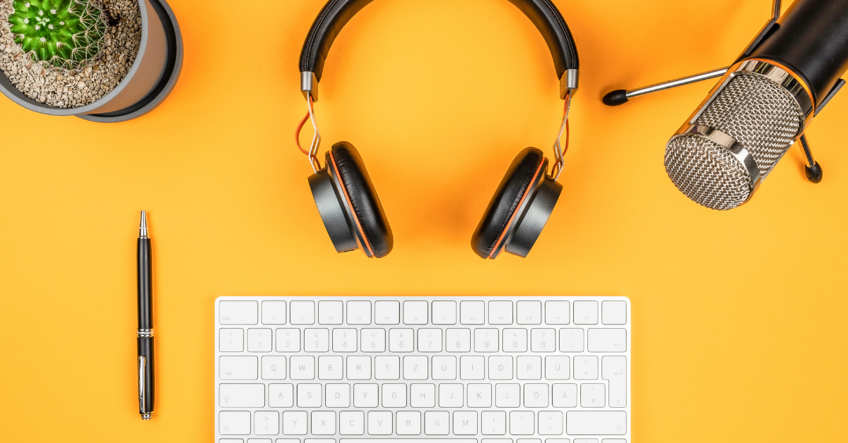 keyboard, headphones, microphone and pen on a yellow table
