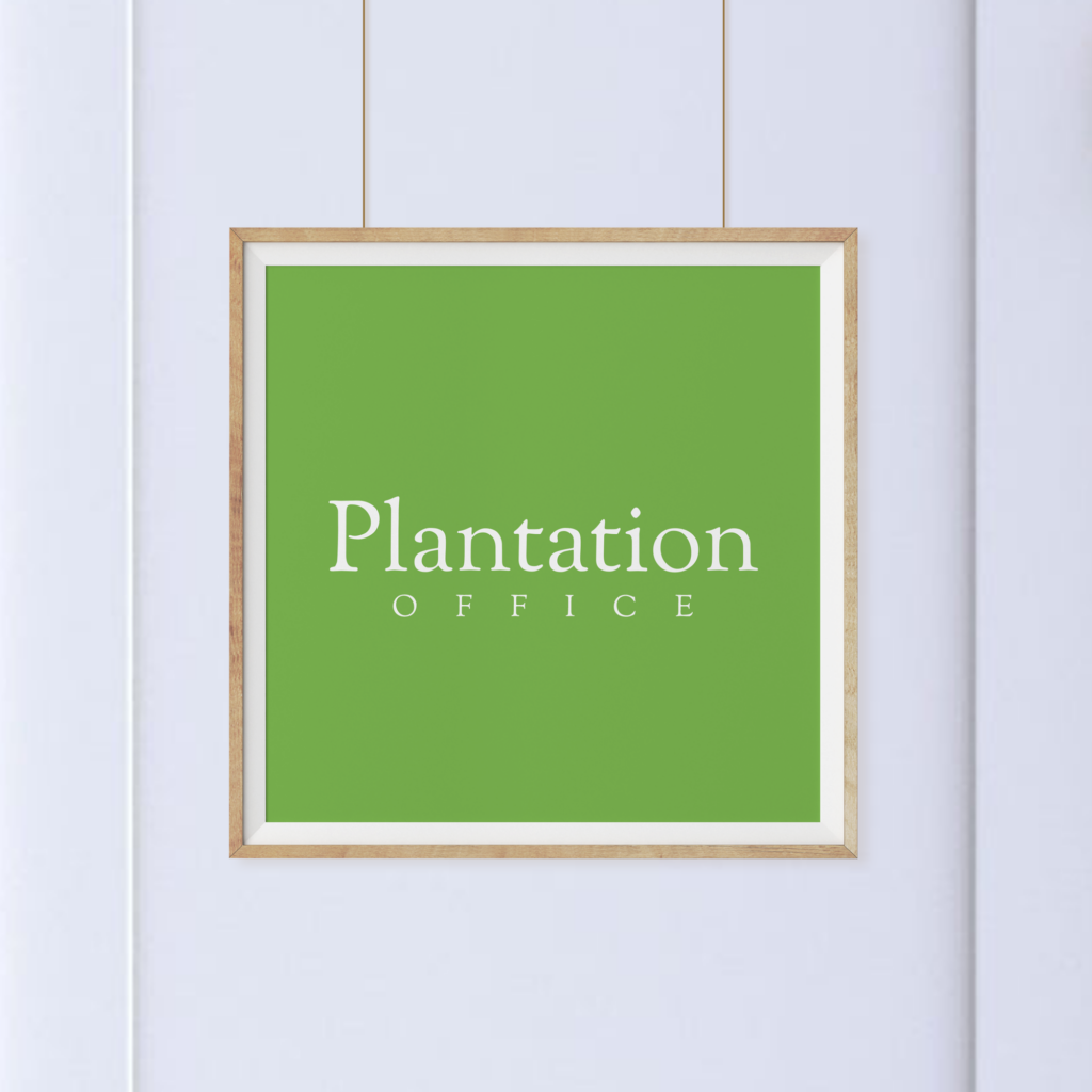 A framed green sign with white text reads "Plantation Office," hanging on a white wall.